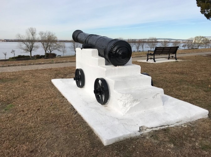 Revolutionary War-era cannon in permanent emplacement along river.