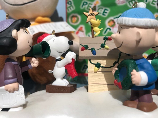 Figurines of Lucy, Snoopy, and Charlie Brown decorating Snoopy’s doghouse.