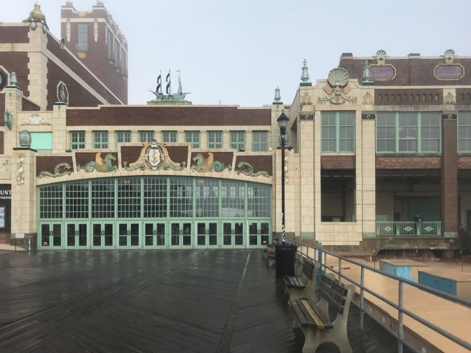 Exterior of Asbury Park Convention Center, with benches on boardwalk in foreground.