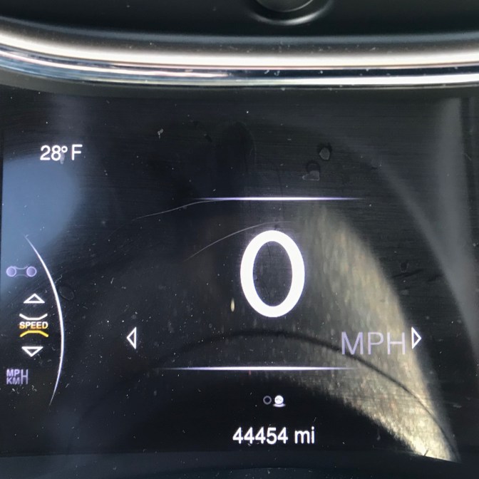 Car odometer that reads 44454 mi. Car speedometer reads 0 MPH.