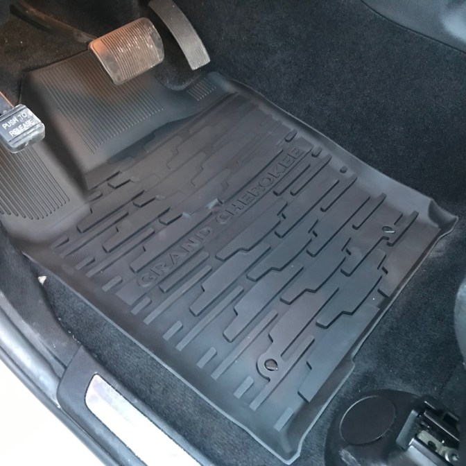 Black all-weather floor mat in driver's side that says GRAND CHEROKEE.