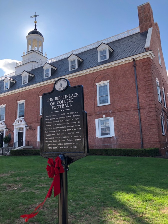 Plaque in front of red brick academic building that says THE BIRTHPLACE OF COLLEGE FOOTBALL.