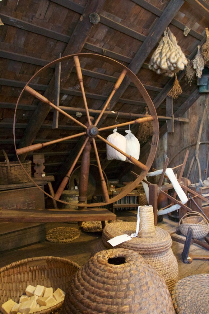 Spinner's wheel set among baskets and boxes.