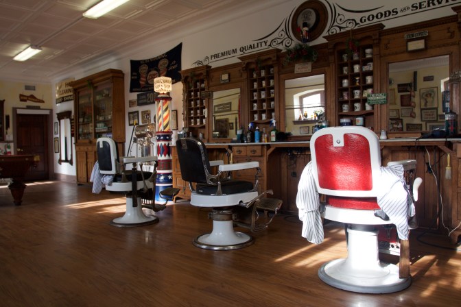Interior of barbershop, with three barber's chairs.