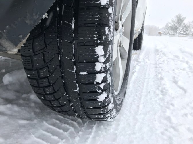 Rear wheel of Jeep and Nokian WR G4 tires, on snowy road.
