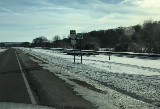 Road signs that say SOUTH 61 63 and GREAT RIVER ROAD.