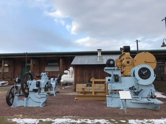 Machinery of ship building on display in plaza beside museum.