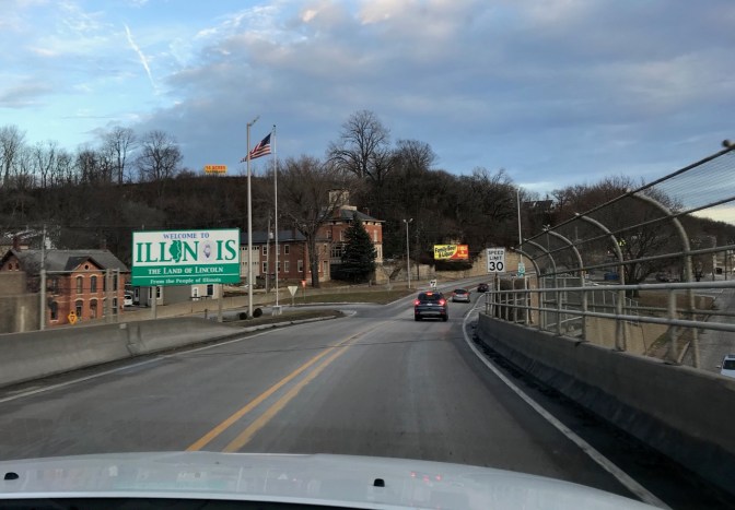 Road with sign on left that says WELCOME TO ILLINOIS.