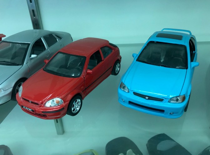 Two Honda Civic die cast toy cars, on in red and one in blue.