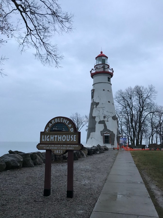 Marblehead Lighthouse with sign in front that says MARBLEHEAD LIGHTHOUSE 1821