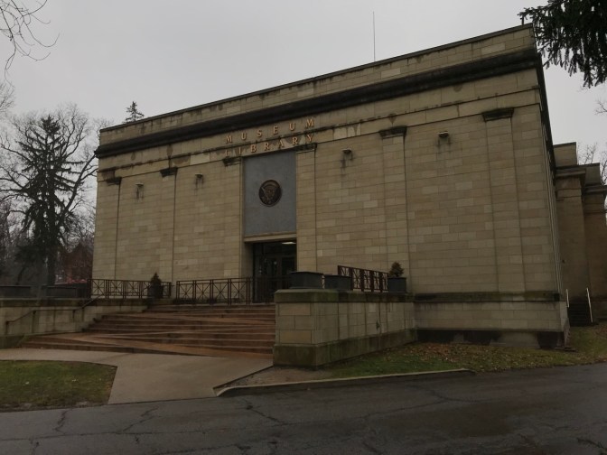 Exterior of museum, with concrete staircase with integrated handicapped access ramp.