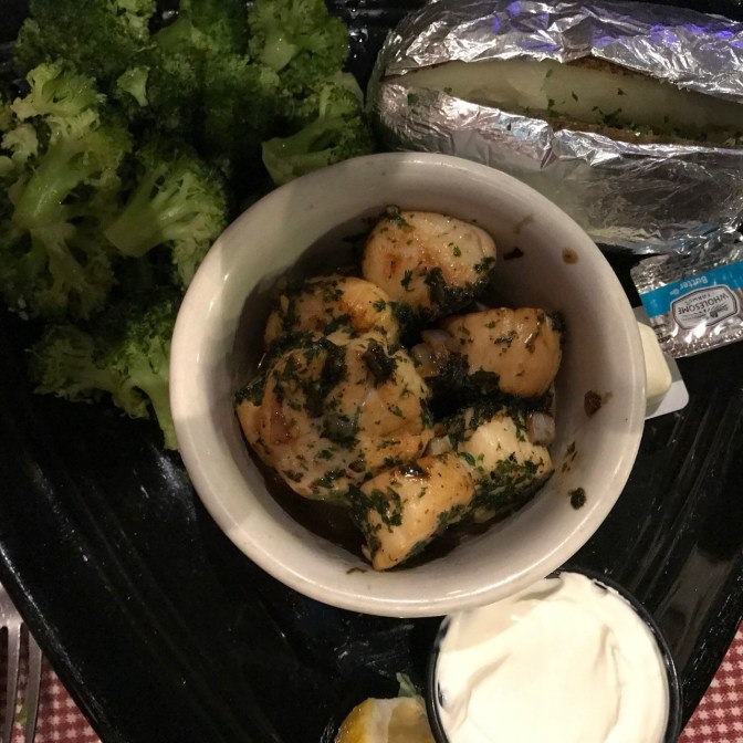 Plate of scallops with baked potato and broccoli.