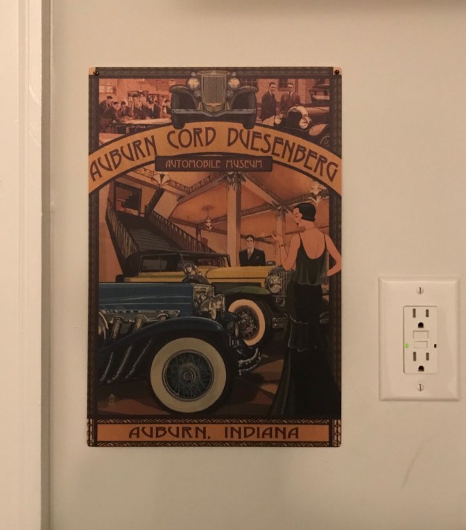 Plaque with picture of classic cars, sign says AUBURN CORD DUESENBERG AUTOMOBILE MUSEUM AUBURN INDIANA.
