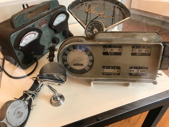 Display with gauge panel from 1951 Ford F-1 pickup, add-on turn signal indicator, Chevy Bel Air dashboard clock and speaker bezel, and Sun Dwell Tachometer.