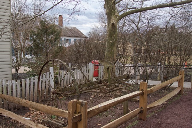 Rusting horse-drawn plow in small plot of ground beside Indian Queen Tavern.