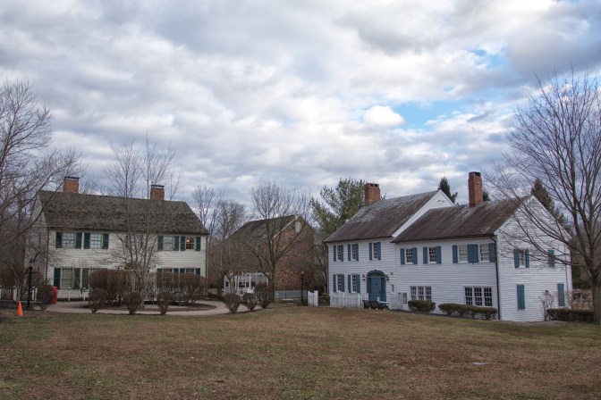 Three buildings at the East Jersey Olde Town, built beside a grassy quad.