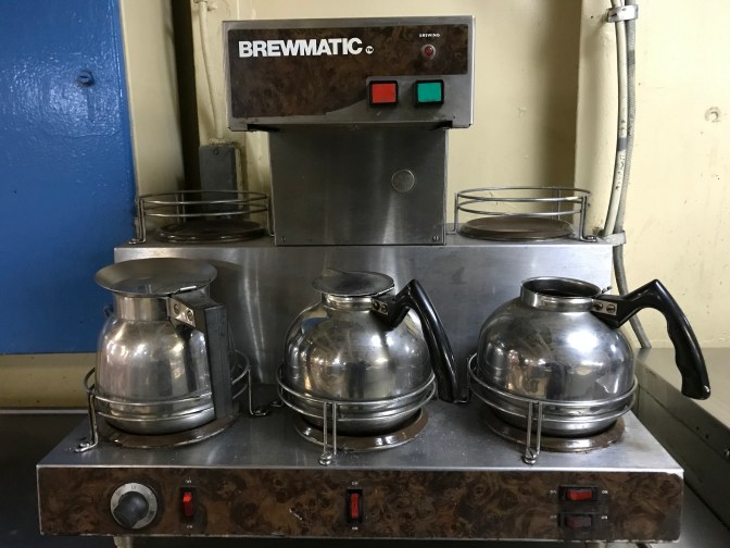 Coffee maker with rails around each burner to secure the pots.