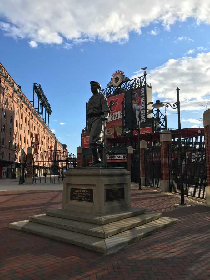 Statue of Babe Ruth, with stadium behind him.