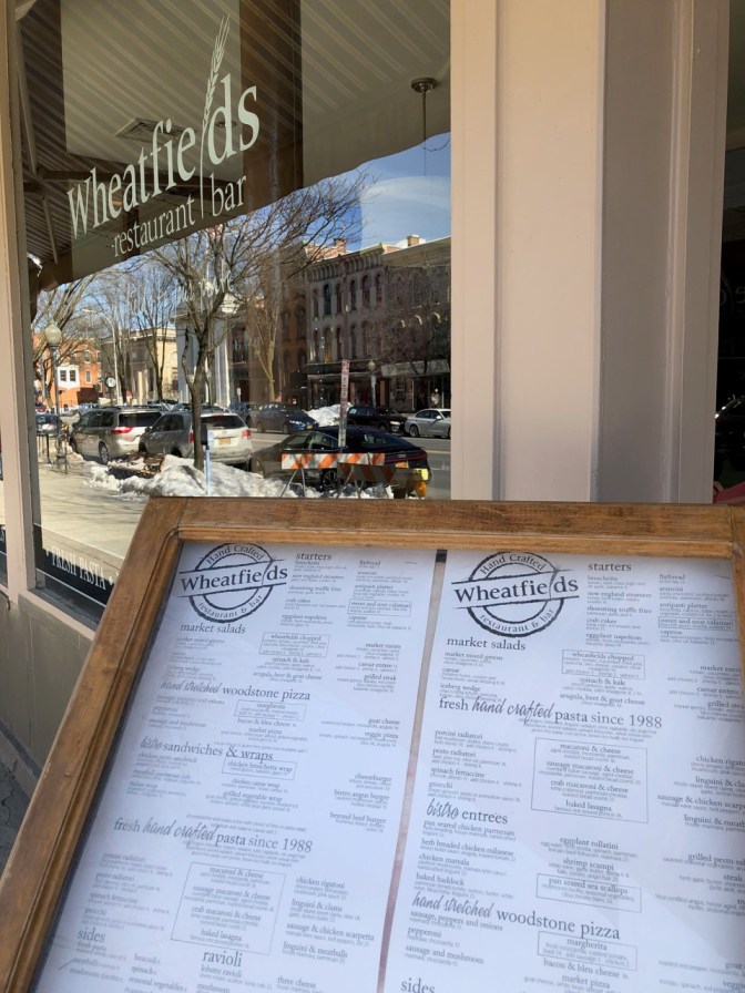 Menu in glass case outside of Wheatfields restaurant and bar.