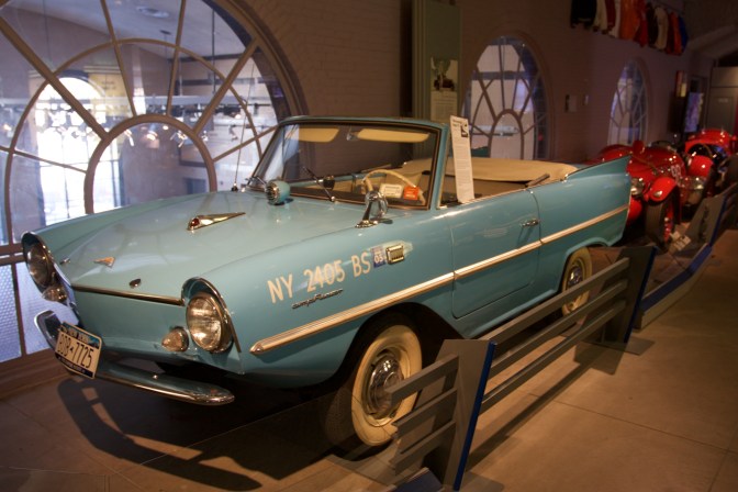 Blue Amphicar on display in row of classic cars.