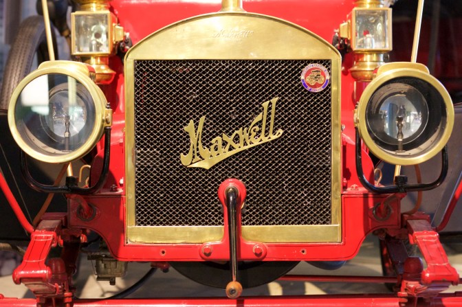 Front end of Maxwell Runabout, including engine crank emerging from grille.