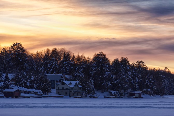 Sunset over lakefront houses.