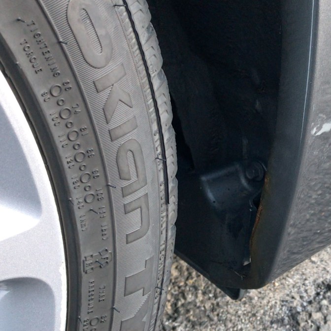 Rust spot on lip of rear quarter panel in wheel well.