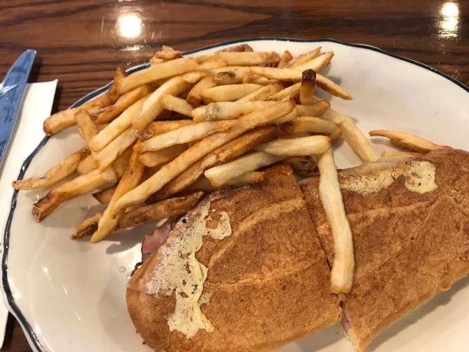 Cuban sandwich on a plate, with fries.