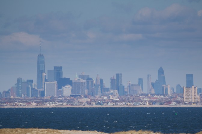 Close-up of Manhattan skyline, with bay water in foreground.