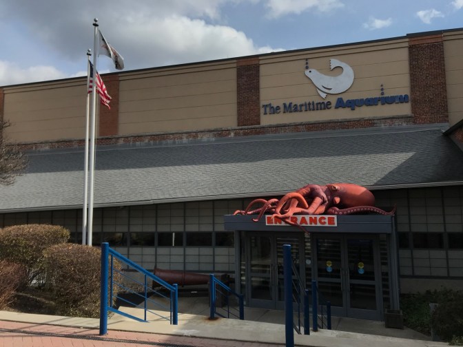 Exterior of The Maritime Aquarium with an inflatable red octopus over the entrance.