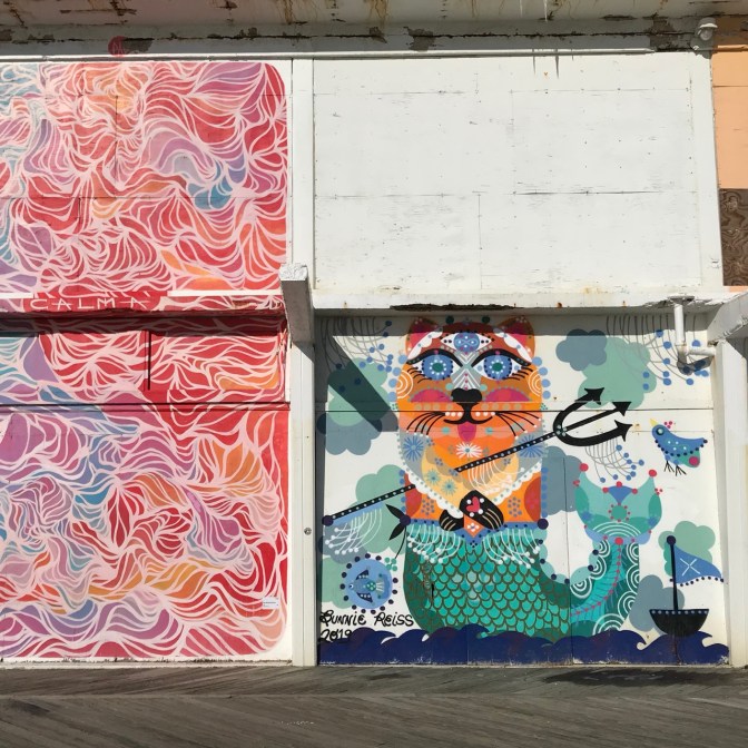 Mural of mermaid cat on wall.