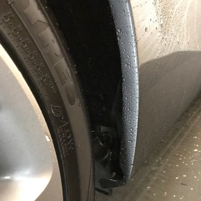 Rear quarter-panel focused on lip of rear wheel well, passenger side.