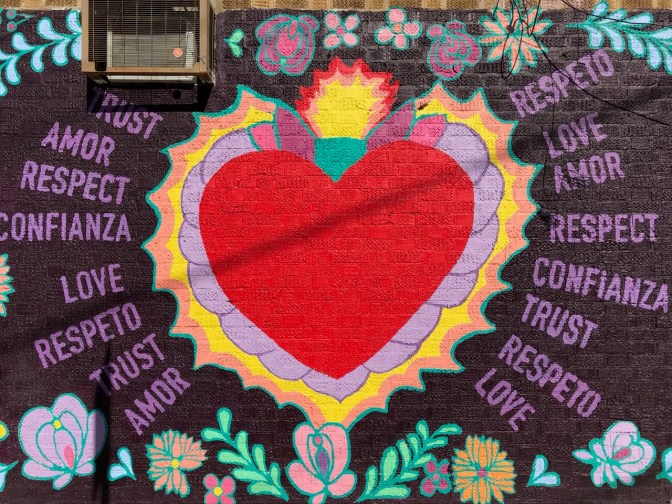 Red heart mural, with words on either side of mural. Left side: Trust amor respect confianza love respeto trust amor Right side: respeto love amor respect confianza trust respeto love.