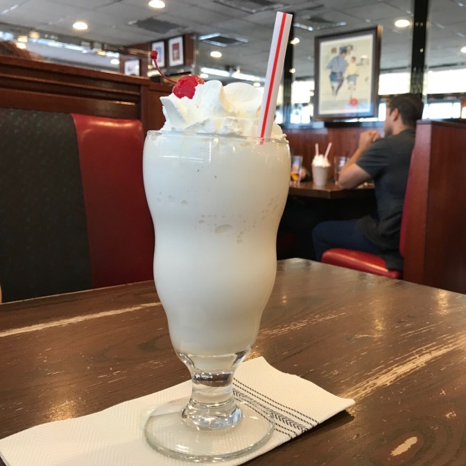 Milkshake in a glass on table.