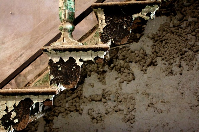 Crumbling paint on stairs, in sepia tone.