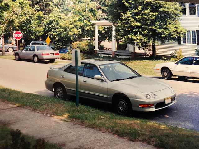 Gold 1998 Acura Integra sedan, parked beside a curb.