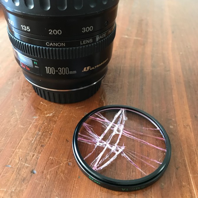 Broken clear filter next to Canon 100-300mm lens.