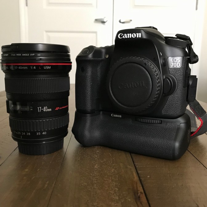 Canon 17-40mm zoom lens and EOS 70D camera body on a wooden table.