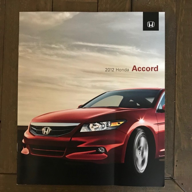 2012 Honda Accord brochure on wooden table.