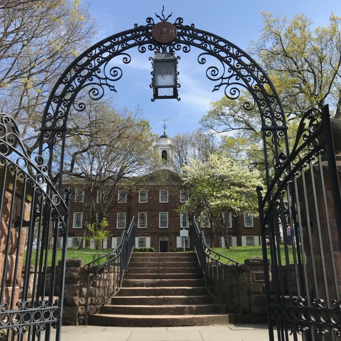 Wrought-iron gate, with Old Queens in background.