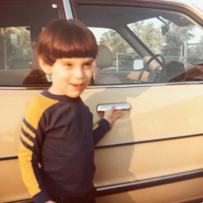 Young boy standing in front of 1980 Honda Accord hatchback.