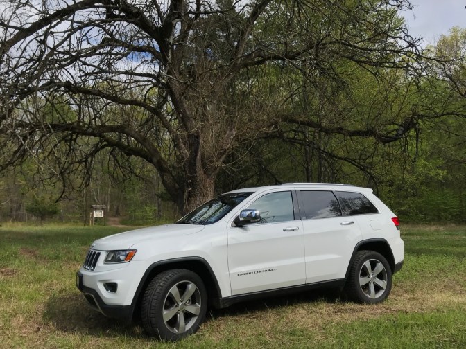 White Jeep Grand Cherokee parked on grassy area of park