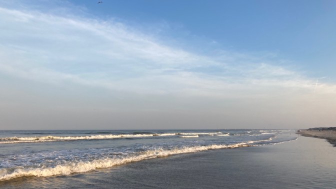 Surf and rolling waves along shore.