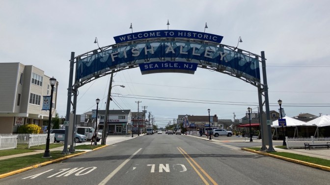 Sign over roadway that says WELCOME TO HISTORIC FISH ALLEY SEA ISLE, NJ