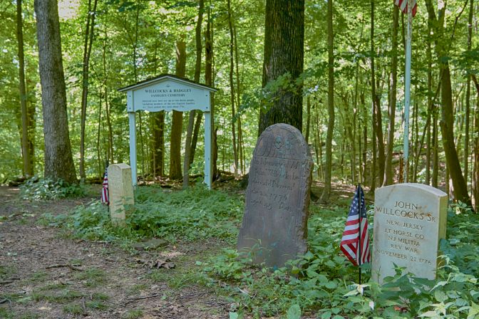 Small graveyard on top of hill in woods.