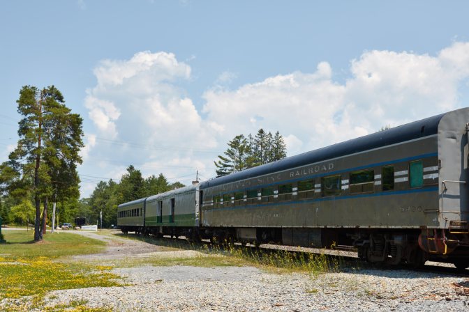 Train coach cars sitting on railroad line.