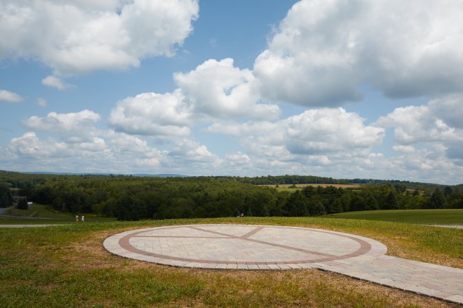 Large stone peace circle in field.