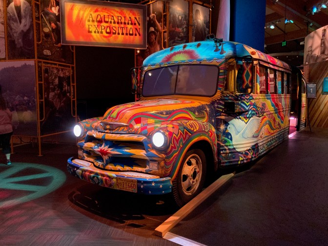 Bus painted in hippie colors with words and murals on it.