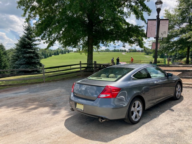 2012 Honda Accord parked in gravel lot, with field in the background.