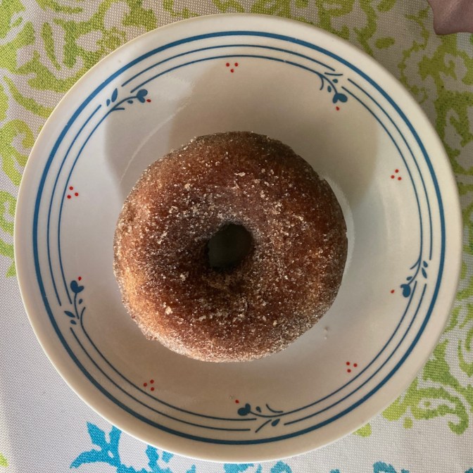 Cinnamon sugar donut on white plate.
